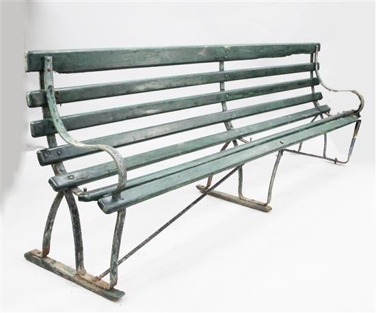 A large green painted railway station bench,